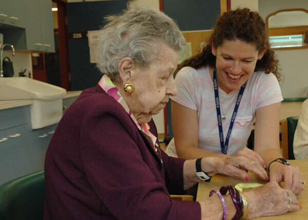 A picture of RHC staff assisting a resident 